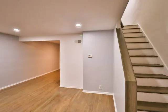 a view of room with stairs and wooden floor