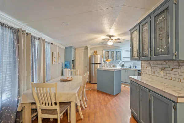 a kitchen with a table chairs sink and cabinets