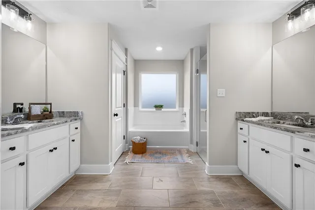 a bathroom with a granite countertop sink a mirror and a bathtub
