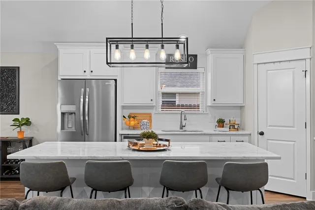 a kitchen with a dining table chairs and refrigerator