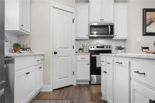 a kitchen with stainless steel appliances white cabinets and a sink