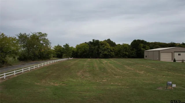 a view of a field with an trees in the background