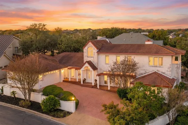 a aerial view of a house with a yard and a large tree
