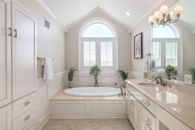 a bathroom with a granite countertop tub a sink and a large mirror