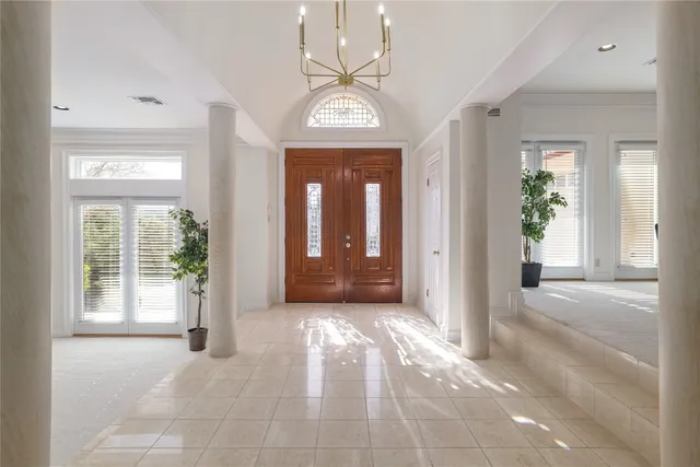 a view of a hallway with windows and chandelier
