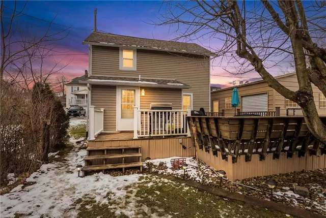 a view of a small house with wooden fence