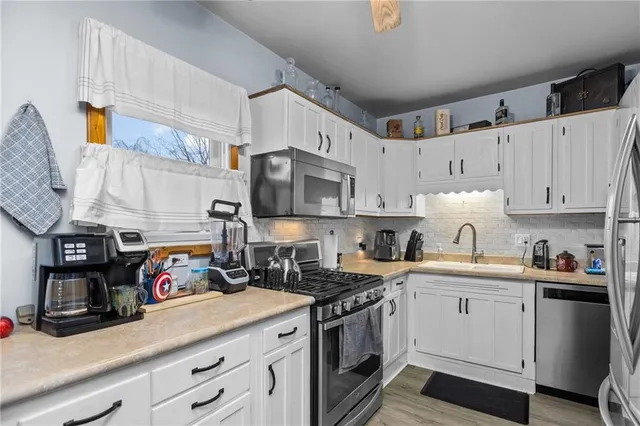a kitchen with stainless steel appliances granite countertop a sink a stove and cabinets