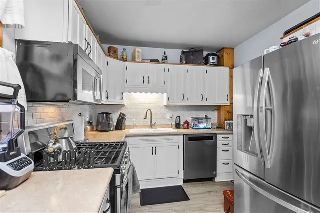 a kitchen with stainless steel appliances a refrigerator sink and cabinets