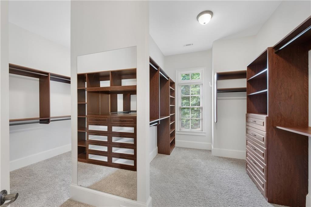 13942 Tree Loft Road Milton, GA 30004 - Photo 40 of 102 a view of walk in closet with clothes and shoes