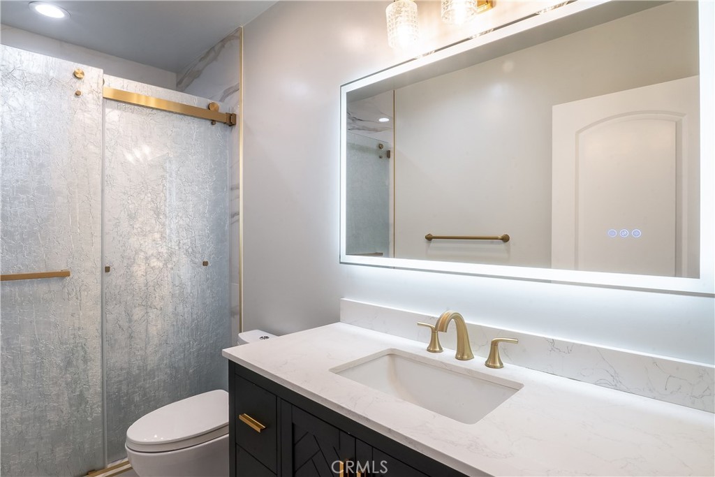 5339 East Greenmeadow Road Long Beach, CA 90808 - Photo 19 of 34 a bathroom with a sink a toilet a mirror and shower