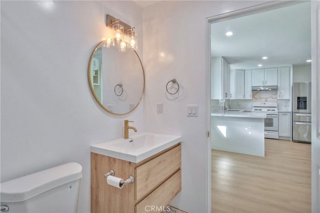 5339 East Greenmeadow Road Long Beach, CA 90808 - Photo 32 of 34 a bathroom with a sink a toilet and a mirror