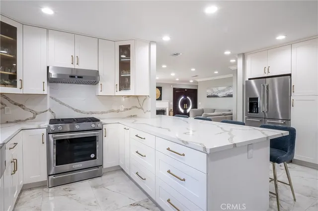 a kitchen with stainless steel appliances granite countertop a stove and a refrigerator