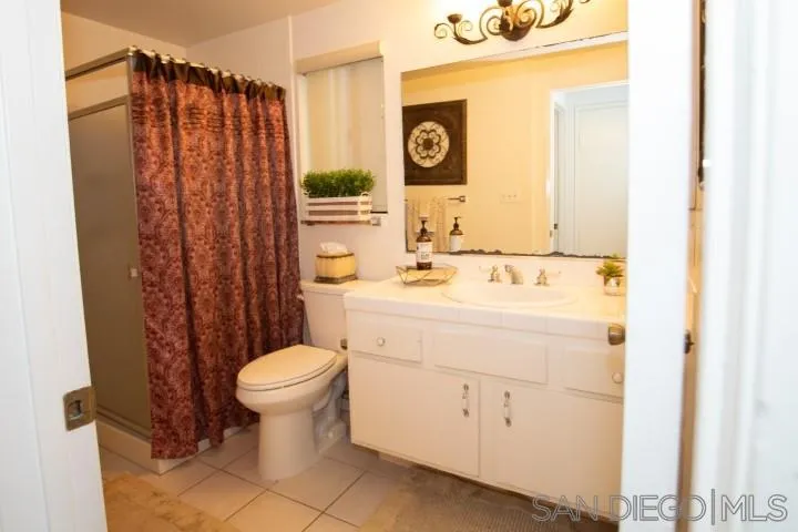 23 Sandpiper Strand Coronado, CA 92118 - Photo 12 of 25 a bathroom with a sink a toilet and shower curtain