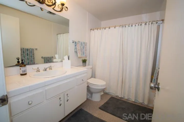 23 Sandpiper Strand Coronado, CA 92118 - Photo 21 of 25 a bathroom with a sink a toilet and shower curtain
