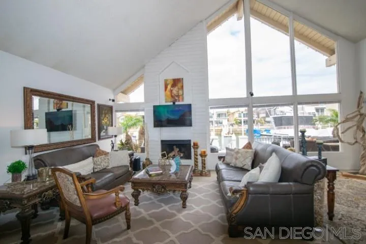 23 Sandpiper Strand Coronado, CA 92118 - Photo 4 of 25 a living room with furniture a fireplace and a floor to ceiling window