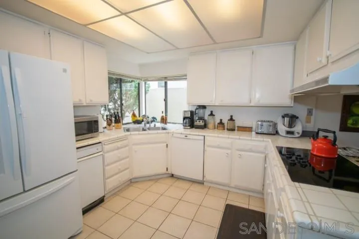 23 Sandpiper Strand Coronado, CA 92118 - Photo 9 of 25 a kitchen with a refrigerator sink and cabinets