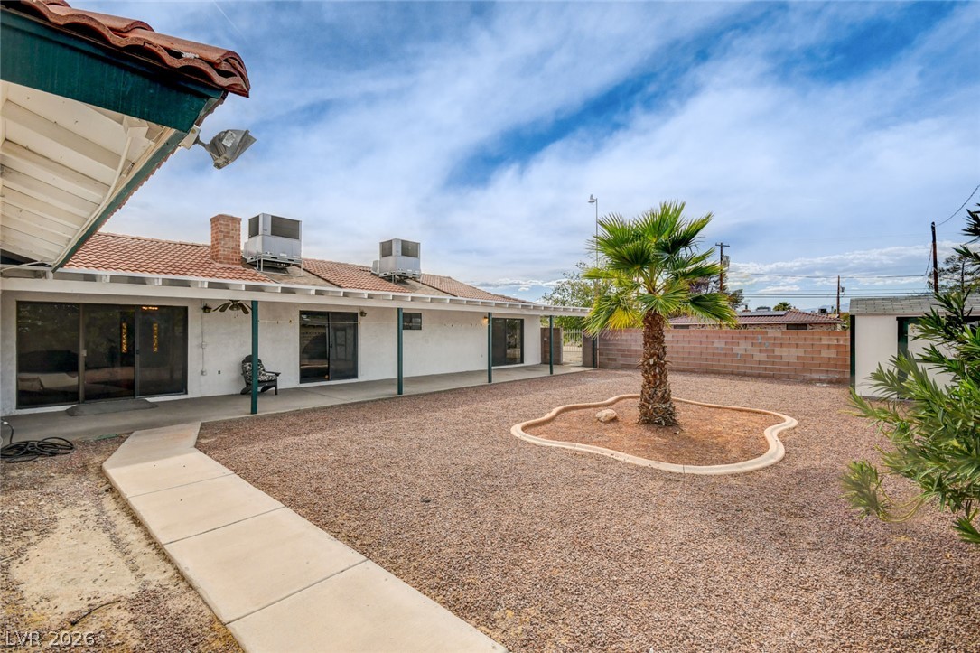 1401 Sharon Road Las Vegas, NV 89106 - Photo 69 of 73 A spacious gravel backyard features a covered concrete patio and a central palm tree.