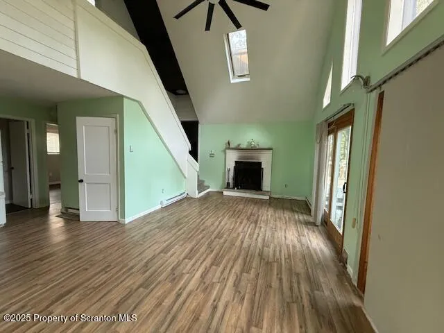 a view of empty room with wooden floor and fan