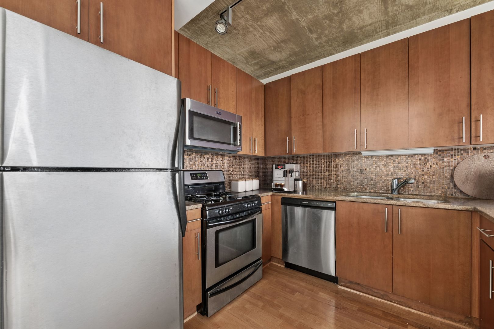 611 South Wells Street, Unit 2904 Chicago, IL 60607 - Photo 7 of 18 a kitchen with stainless steel appliances granite countertop a refrigerator sink stove and microwave