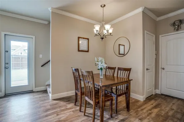 a view of a dining room with furniture a chandelier and wooden floor