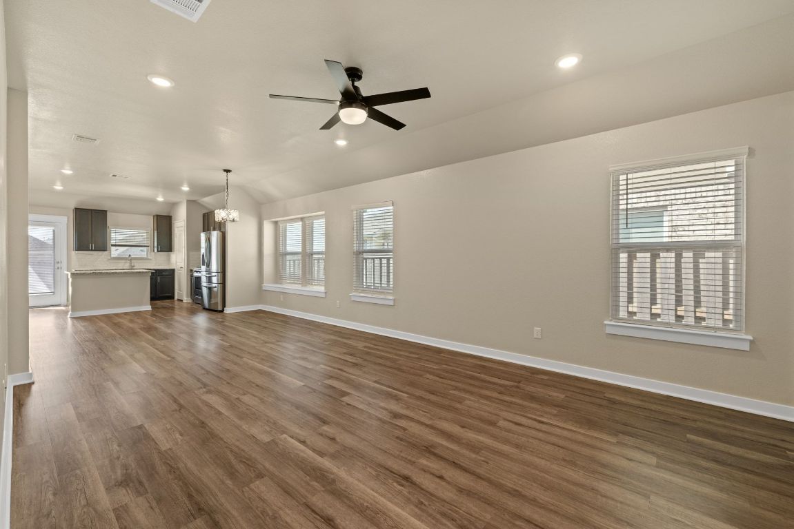 1304 Salt Lick Drive Georgetown, TX 78633 - Photo 9 of 40 a view of an empty room with a kitchen and wooden floor