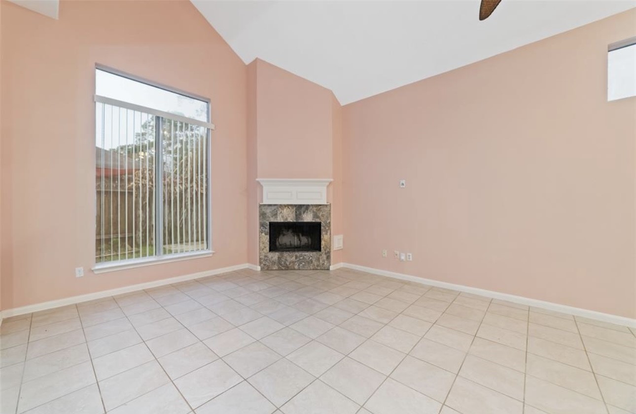 18715 Scented Candle Way Spring, TX 77388 - Photo 11 of 24 a view of an empty room with a fireplace and a window