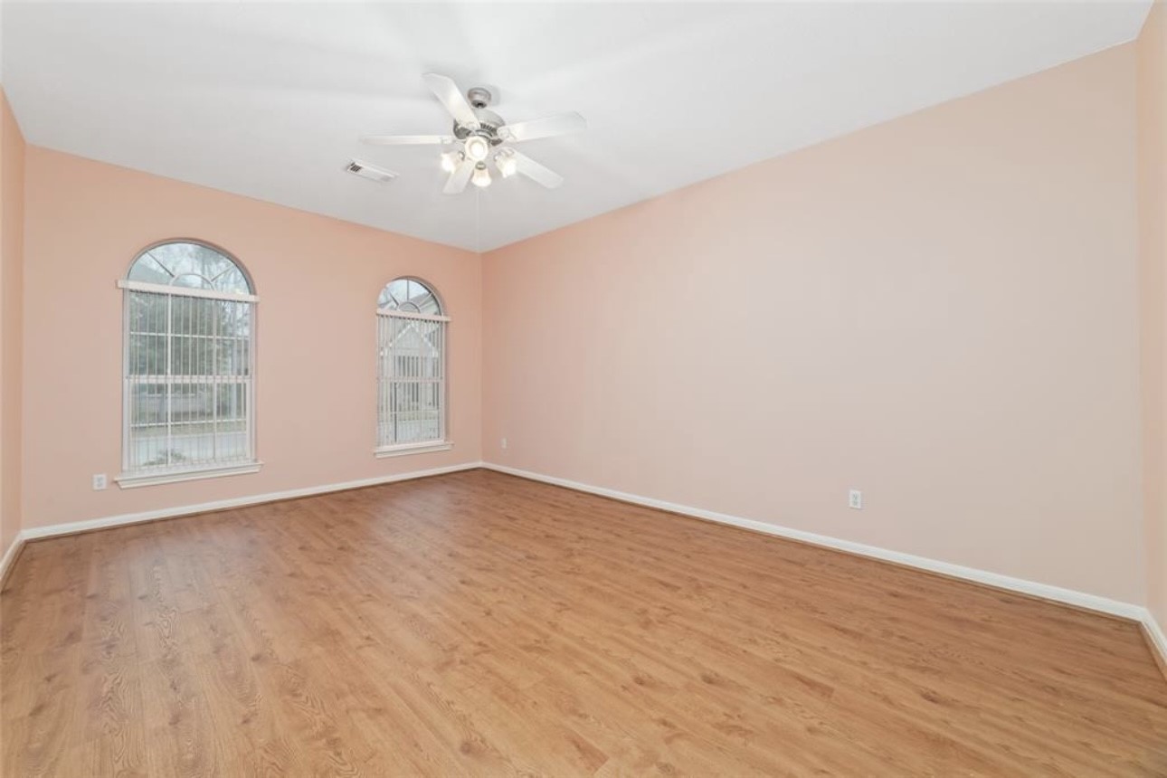 18715 Scented Candle Way Spring, TX 77388 - Photo 16 of 24 a view of an empty room with wooden floor and a window
