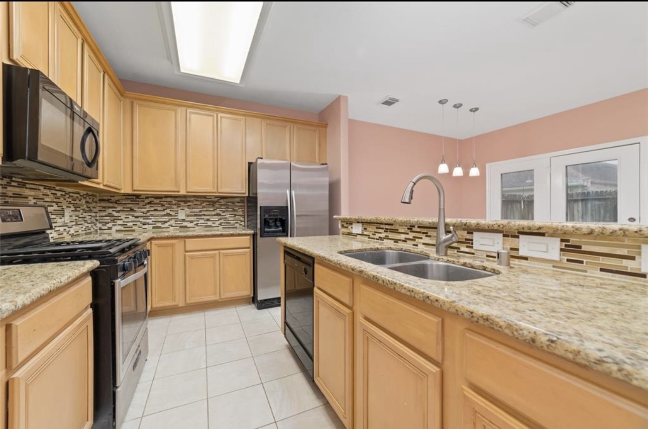 18715 Scented Candle Way Spring, TX 77388 - Photo 8 of 24 a kitchen with a sink stove and refrigerator