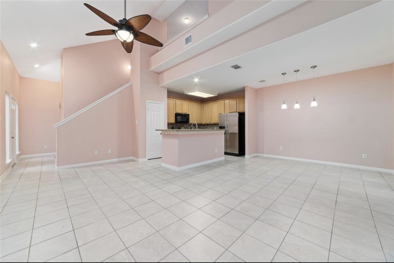 18715 Scented Candle Way Spring, TX 77388 - Photo 10 of 24 an empty room with kitchen and chandelier fan