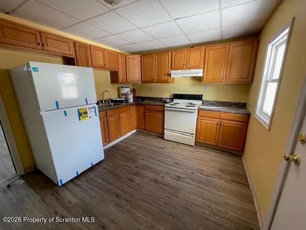 a kitchen with stainless steel appliances a refrigerator a sink a stove a microwave and cabinetry