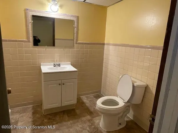 a bathroom with a toilet sink and mirror