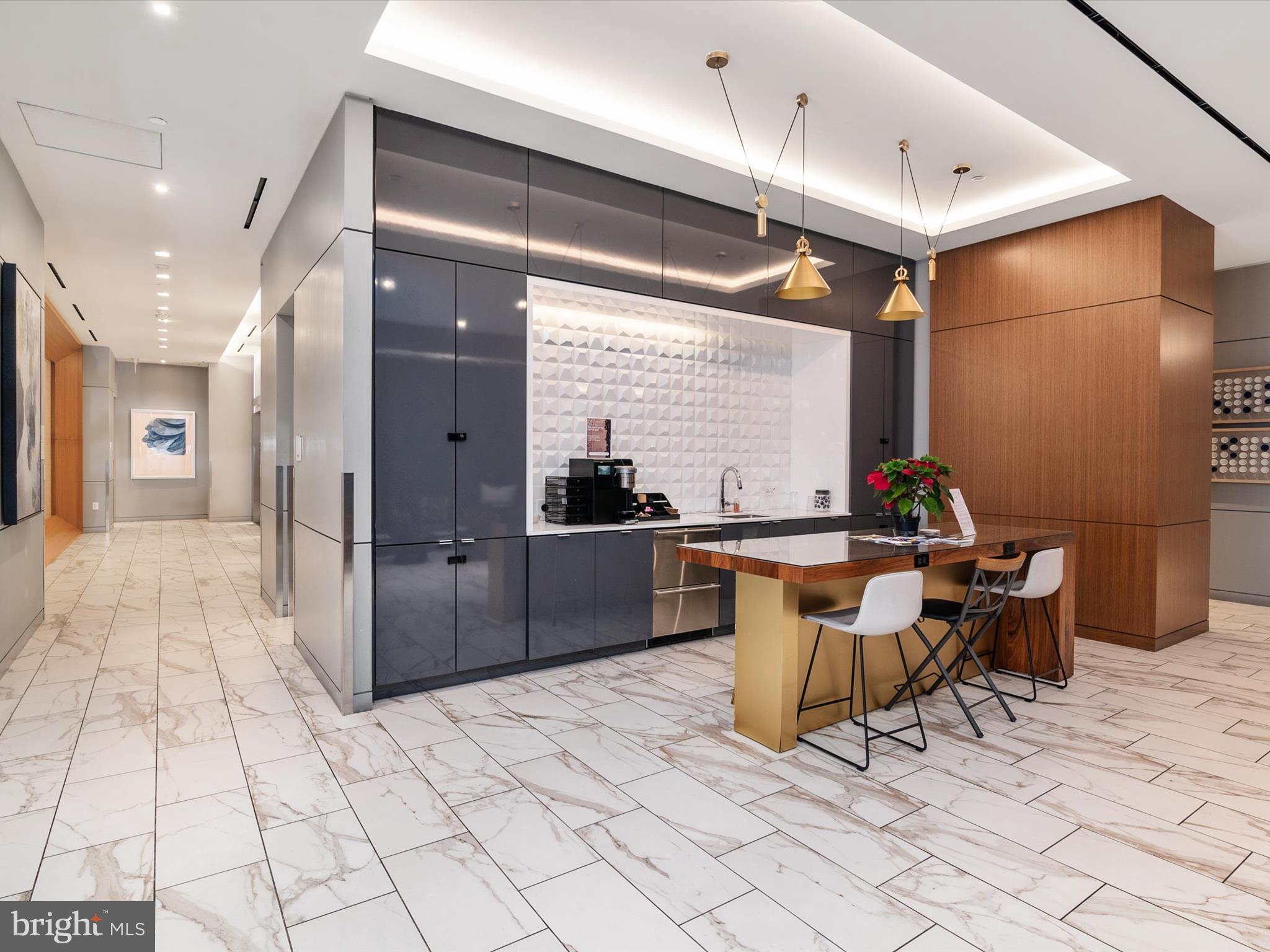 1211 Van Street Southeast, Unit 1110 Washington, DC 20003 - Photo 34 of 46 a room with stainless steel appliances kitchen island granite countertop a table and chairs in it