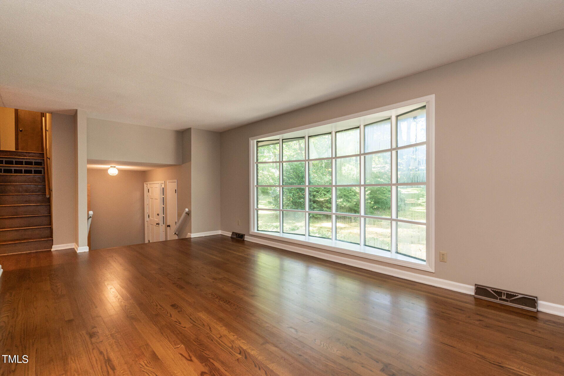 6604 Brandywine Road Raleigh, NC 27607 - Photo 2 of 46 a view of an empty room with wooden floor and a window