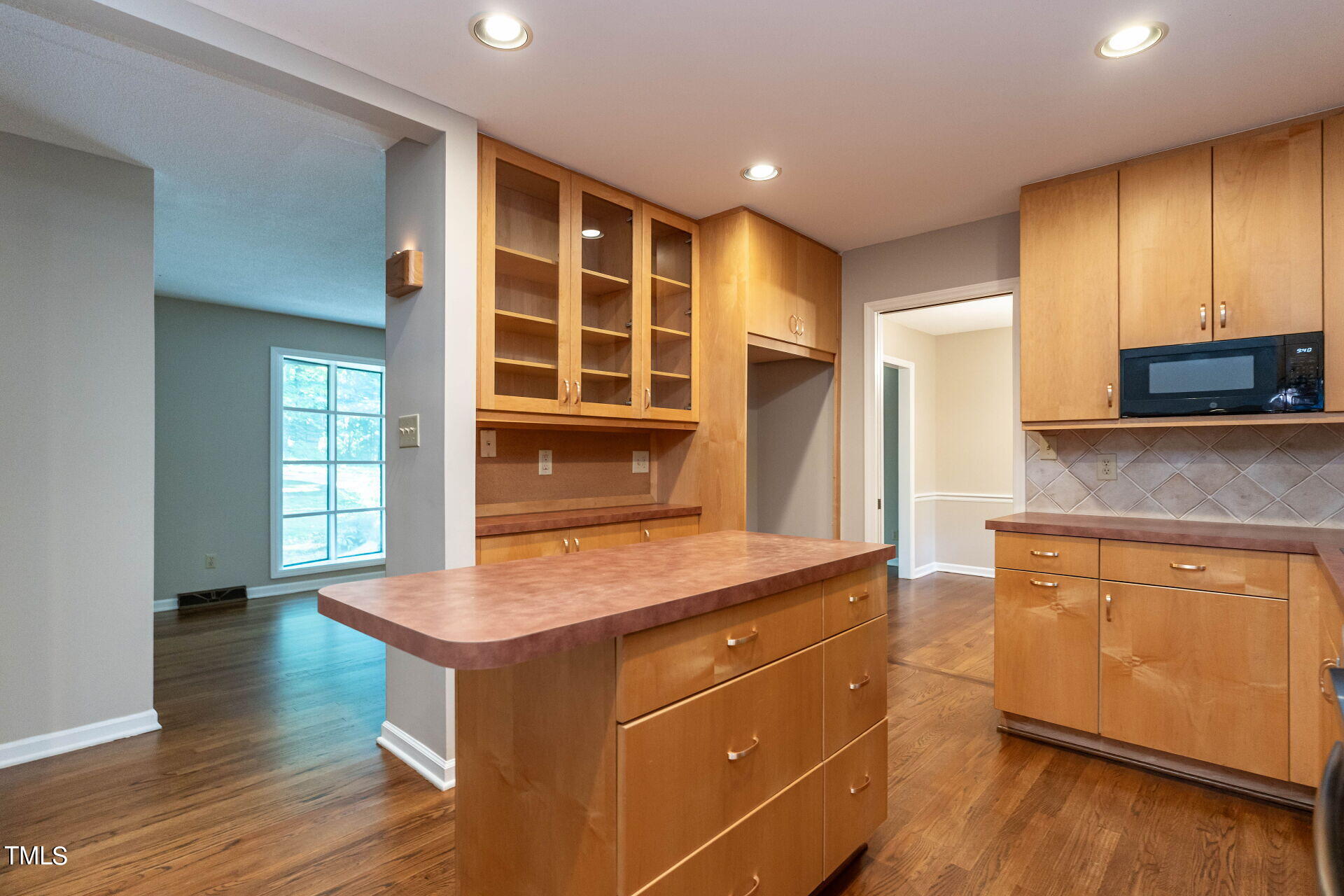 6604 Brandywine Road Raleigh, NC 27607 - Photo 24 of 46 a kitchen with kitchen island granite countertop wooden cabinets and white appliances