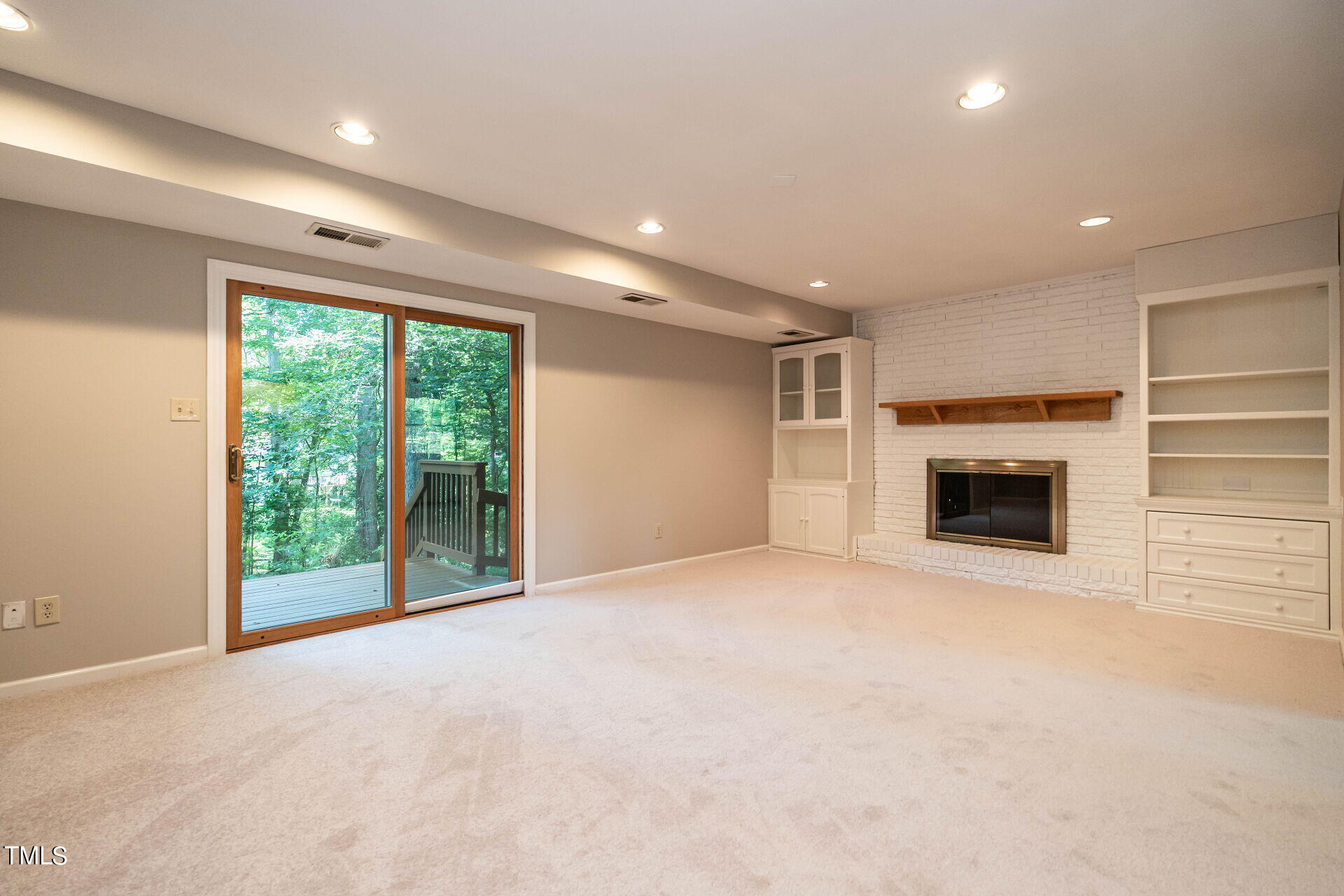 6604 Brandywine Road Raleigh, NC 27607 - Photo 7 of 46 a view of an empty room with a fireplace and a window