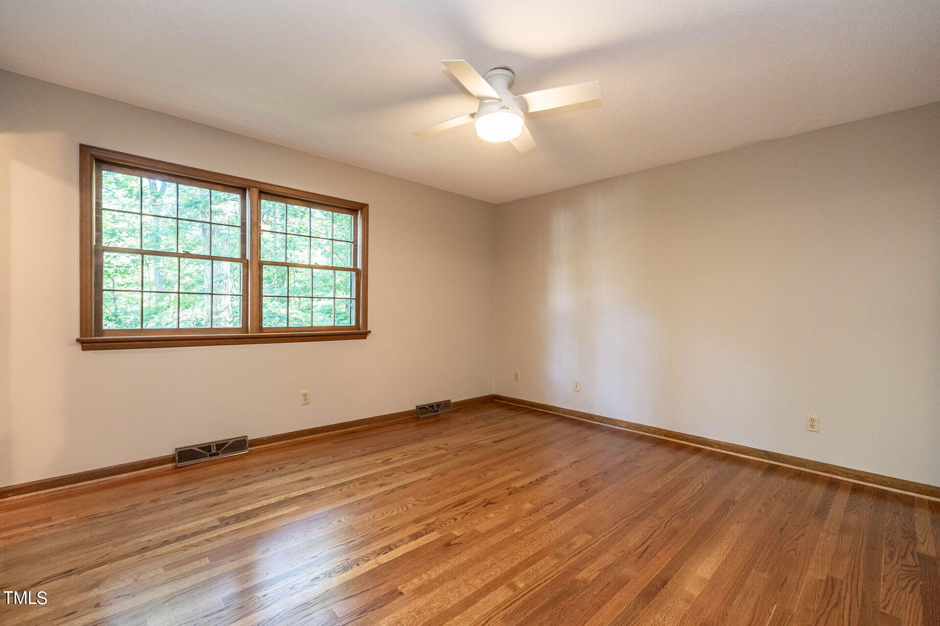 6604 Brandywine Road Raleigh, NC 27607 - Photo 9 of 46 an empty room with wooden floor and windows