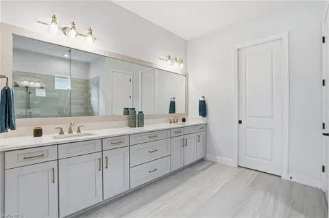 a bedroom with a bed couch chandelier and a window