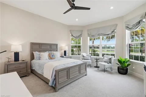 a bedroom with a bed chandelier and window