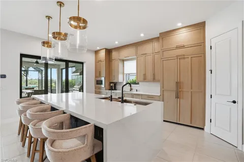 a large kitchen with stainless steel appliances kitchen island granite countertop a sink and a stove