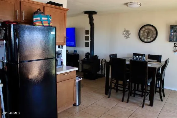 a kitchen with stainless steel appliances granite countertop a refrigerator a stove a dining table and chairs