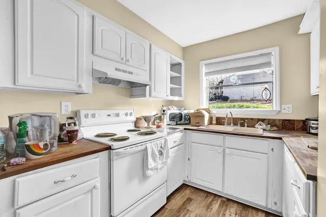 a kitchen with granite countertop white cabinets white appliances and sink