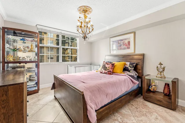 a bedroom with a bed and a chandelier