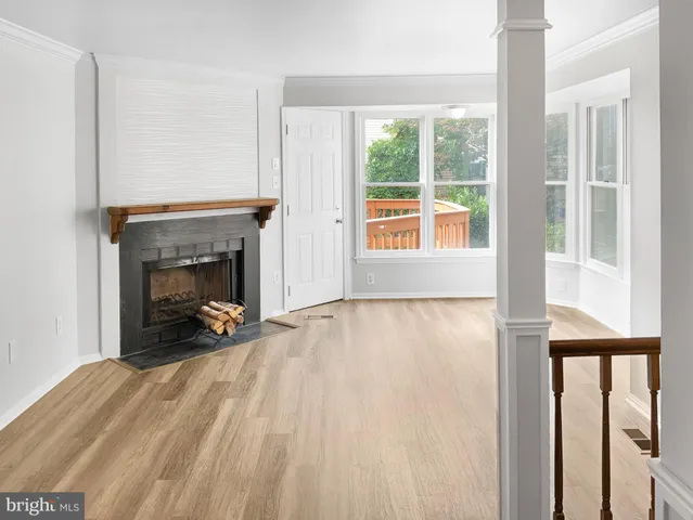 a view of an empty room with a fireplace and a window