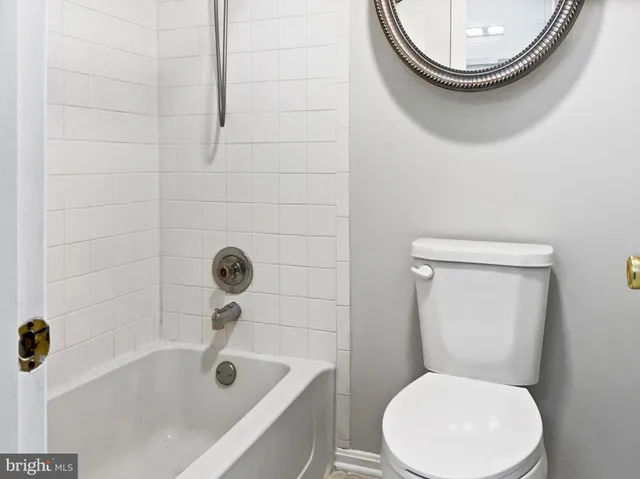 a white toilet sitting next to a bath tub