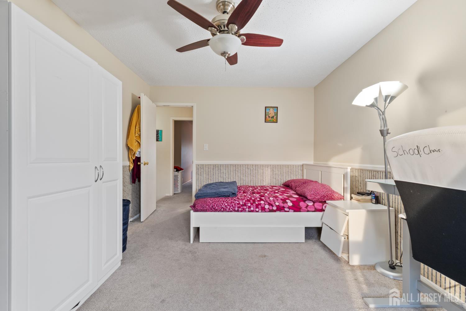 348 Westgate Drive Edison, NJ 08820 - Photo 31 of 43 a bedroom with a bed and a chandelier