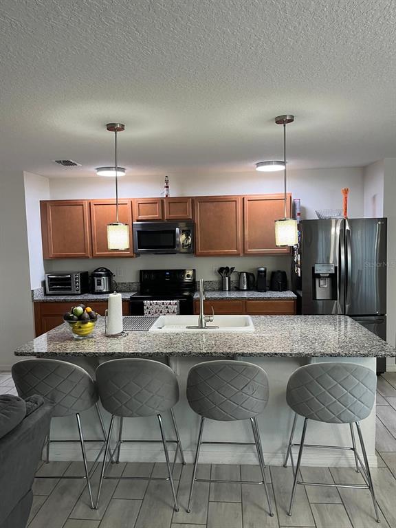 4668 Glencrest Loop St. Cloud, FL 34772 - Photo 5 of 5 a kitchen with a dining table chairs and a refrigerator