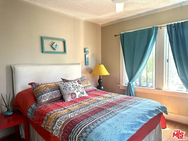 a bedroom with a bed and a lamp on dresser