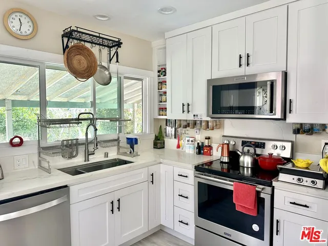 a kitchen with stainless steel appliances a stove a sink a stove and a microwave