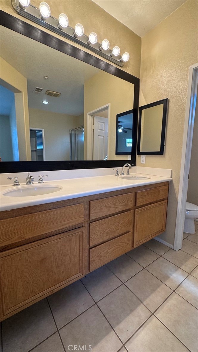 11332 Riverbury Court Riverside, CA 92505 - Photo 4 of 15 a bathroom with a sink a large mirror and a vanity
