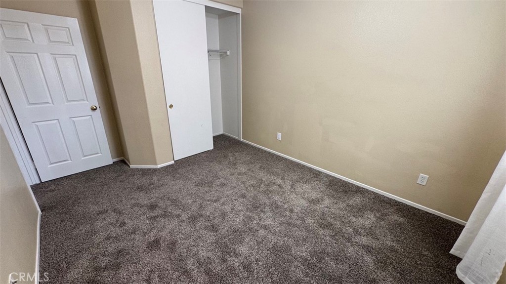 11332 Riverbury Court Riverside, CA 92505 - Photo 9 of 15 an empty room with wooden floor and mirror